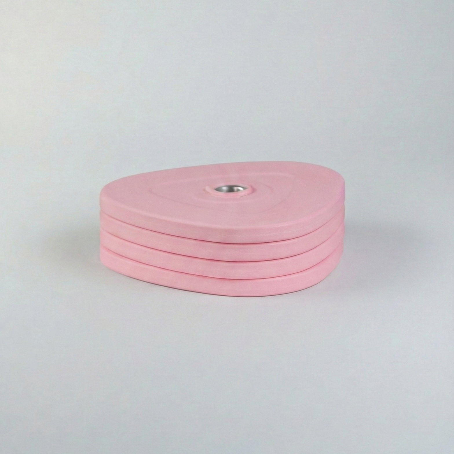 Stack of pink weight plates on a light gray background